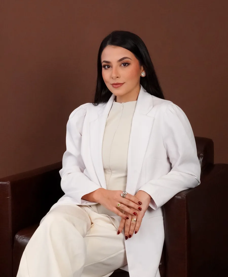 Dra. Júlia Tenório, ginecologista em Arapiraca e Maceió, de jaleco branco em seu consultório