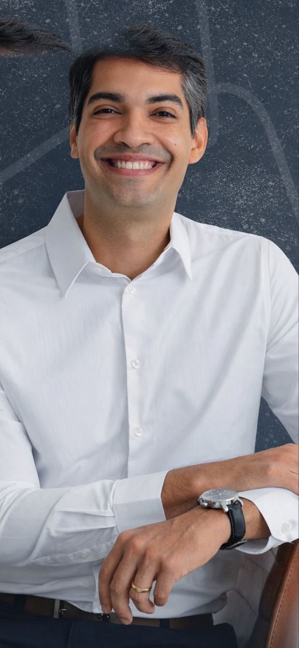 Dr. Eduardo Rios, pediatra, sorrindo de camisa branca
