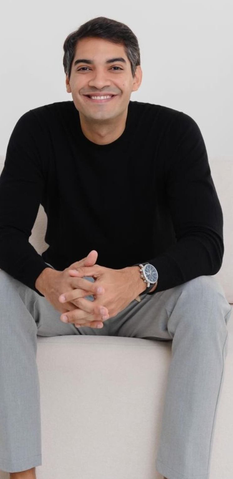 Pediatra Dr. Eduardo Rios sentado em consultório, sorrindo
